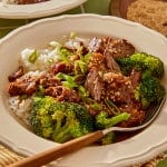 Slow cooker mongolian beef served in a bowl and garnished with green onions and sesame seeds.