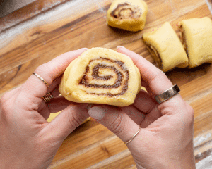 Cutting the rolled up cinnamon roll cookie dough into 20-24 individual cuts before rolling.