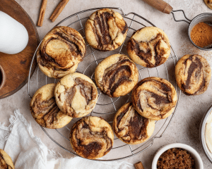 Unfrosted cinnamon roll cookies cooling on wire rack.