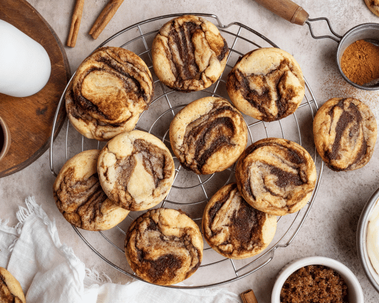 Unfrosted cinnamon roll cookies cooling on wire rack.