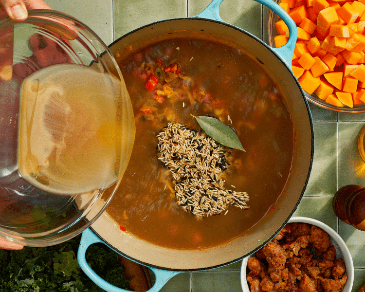 Adding the wild rice and chicken broth to creamy harvest soup.