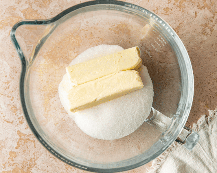 Butter and sugar in a clear mixing bowl before creaming together.