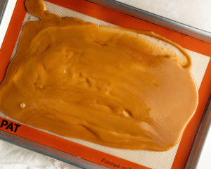 Letting cooked toffee cool on prepared 9x13 baking sheet.