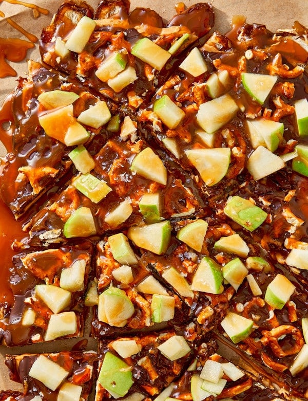 Breaking salted caramel apple date bark into pieces after chilling for at least 30 minutes.