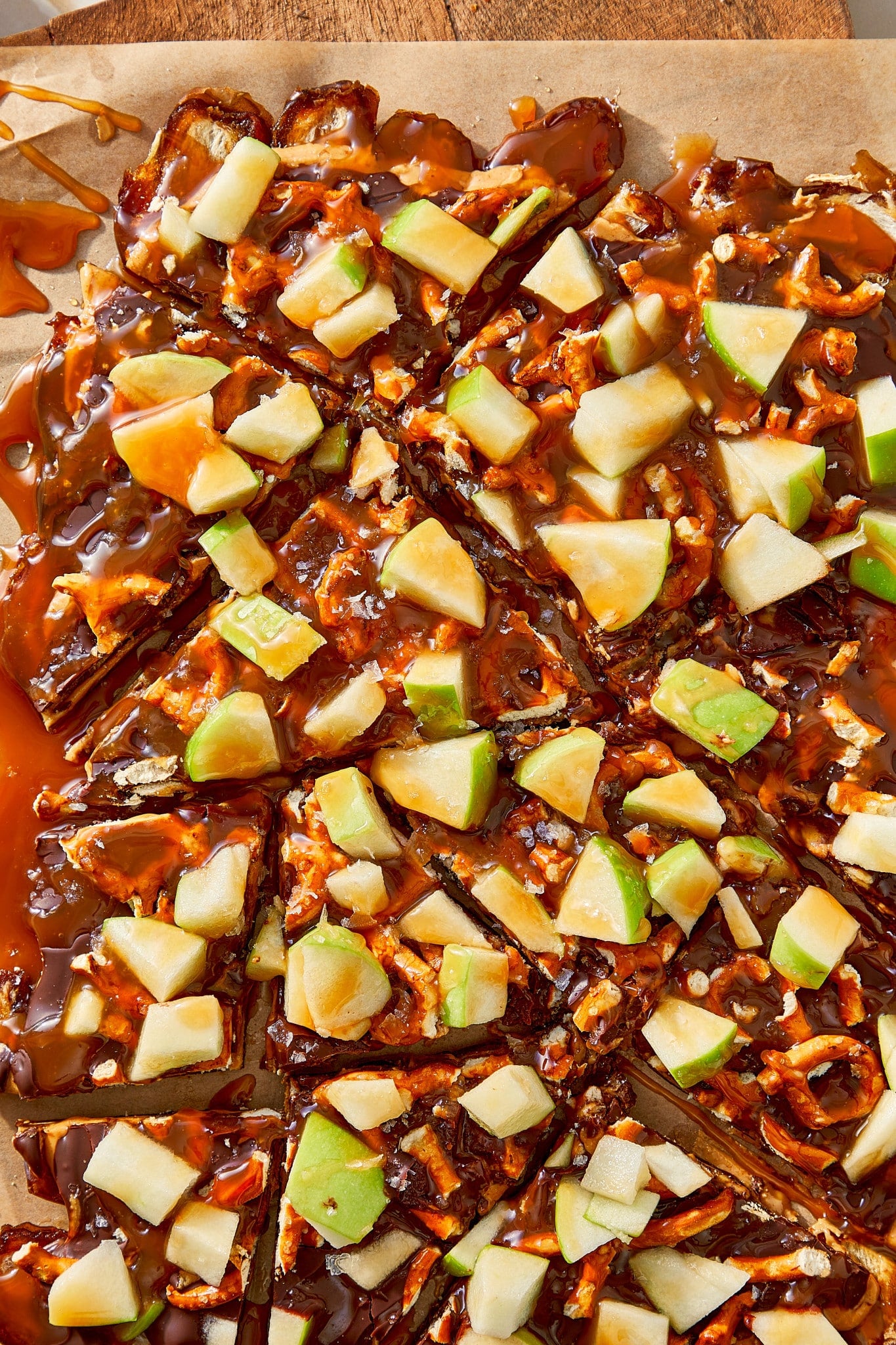 Breaking salted caramel apple date bark into pieces after chilling for at least 30 minutes.