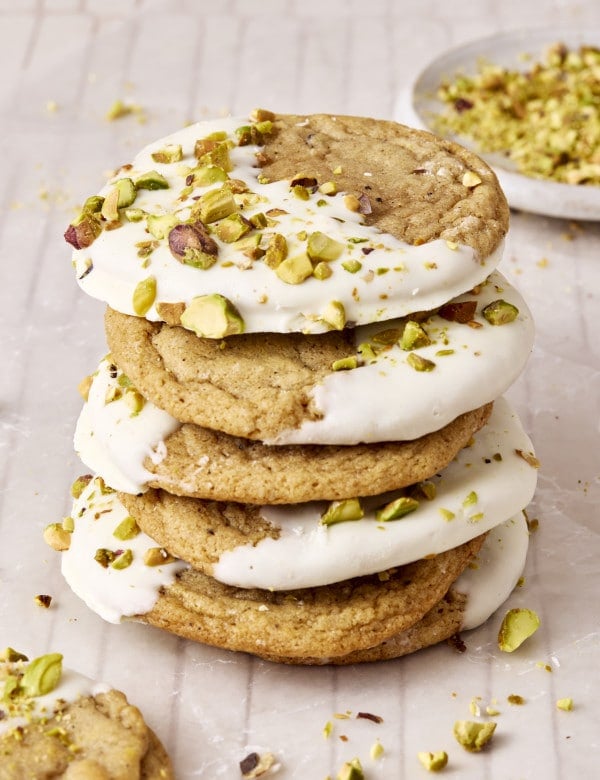 Four white chocolate dipped brown sugar cookies stacked on top of each other after the white chocolate has set.