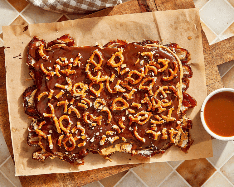 Adding pretzels on top of chocolate layer for date bark.