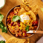 Featured image of chicken taco soup served in a bowl with toppings.