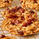 Healthy breakfast cookies stacked together on a wire rack with the top cookie missing a bite out of it.