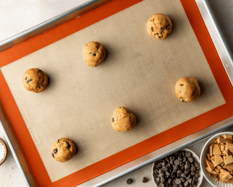 Placing six cookie dough balls on prepared baking sheet.